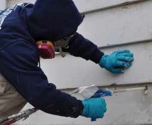 Worker installing wall insulation.