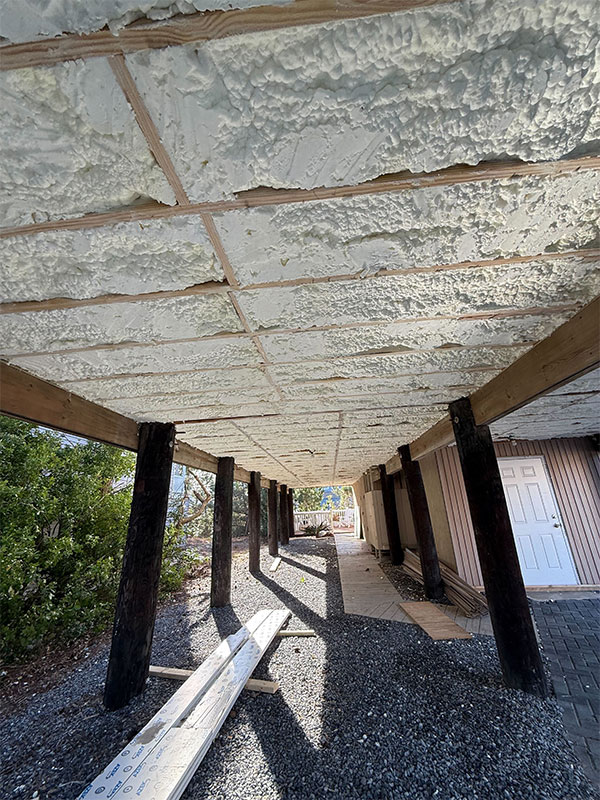 A detailed view of a cold floor insulated with 8 inches of open-cell foam (R-30) in Fenwick Island, DE. This innovative solution ensures optimal thermal protection for heated spaces above unheated areas, like garages or basements.