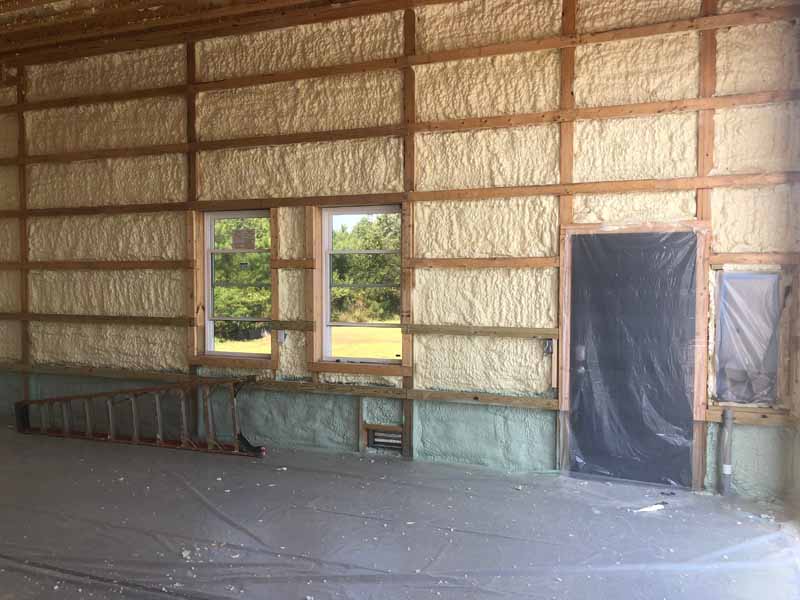 Interior framing with spray foam insulation applied to walls in new construction.
