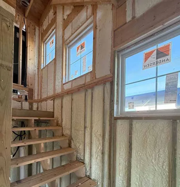 Closed cell spray foam insulation applied to stairwell walls in a new residential build.